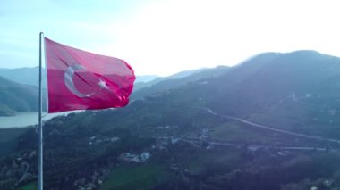 Dağın tepesinde Türk bayrağı var. Tepesinde güzel manzaralı Türk bayrağı var. Türk bayramları. 23 Nisan, 19 Mayıs, 30 Agustos, 29 Ekim konsepti. İHA görüntüsü. Havadan sinematik çekim.
