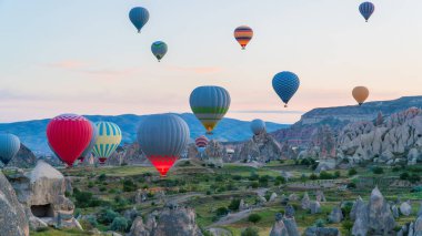 Kapadokya hindisi. Kapadokya 'da güneş doğarken bacaların üzerinde uçan sıcak hava balonları. Türkiye 'ye git. Türkiye 'nin turistik simgeleri. Seçici odak dahil