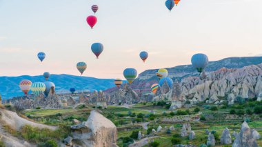 Kapadokya hindisi. Kapadokya 'da güneş doğarken bacaların üzerinde uçan sıcak hava balonları. Türkiye 'ye git. Türkiye 'nin turistik simgeleri. Seçici odak dahil