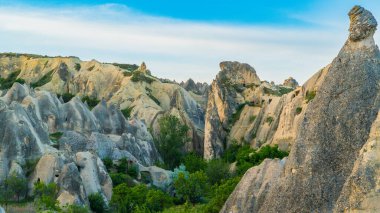 Kapadokya hindisi. Kapadokya 'da güneş doğarken bacaların üzerinde uçan sıcak hava balonları. Türkiye 'ye git. Türkiye 'nin turistik simgeleri. Seçici odak dahil