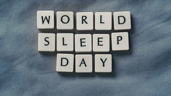 小さな文字の石と世界睡眠デーの概念 柔らかいベッドシートの上の睡眠の概念 高角度表示 — ストック写真