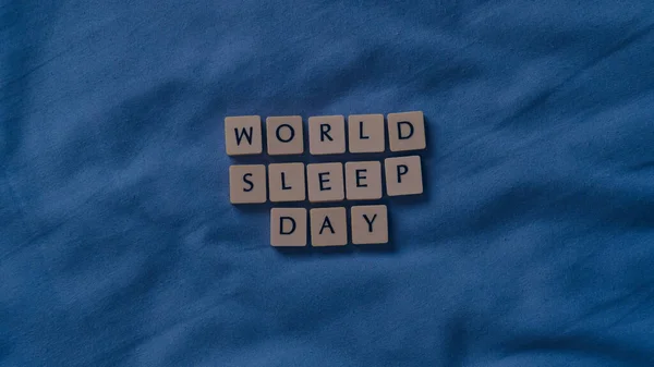 小さな文字の石と世界睡眠デーの概念 柔らかいベッドシートの上の睡眠の概念 高角度表示 — ストック写真
