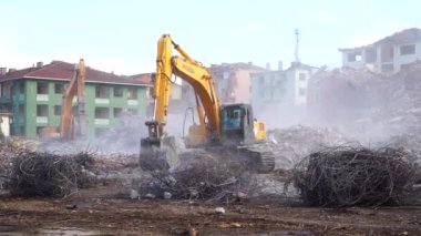 Türkiye 'de kentsel dönüşüm. Şehir yenilenmesi. Yenilerini yapmak için eski binaları yıkıyorlar. İnşaat alanında çalışan bir kazıcı. İstanbul, Türkiye, 17 Haziran 2023.