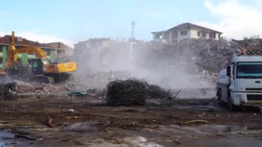 Türkiye 'de kentsel dönüşüm. Şehir yenilenmesi. Yenilerini yapmak için eski binaları yıkıyorlar. İnşaat alanında çalışan bir kazıcı. İstanbul, Türkiye, 17 Haziran 2023.