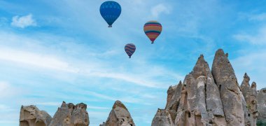 Kapadokya hindisi. Kapadokya 'da güneş doğarken bacaların üzerinde uçan sıcak hava balonları. Türkiye 'ye git. Türkiye 'nin turistik simgeleri. Seçici odak dahil