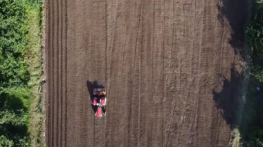 Tarımsal alan hava görüntüsü. Tarlada çalışan traktörlü bir çiftçi. Traktör tohum ekmek için toprağı hazırlıyor.