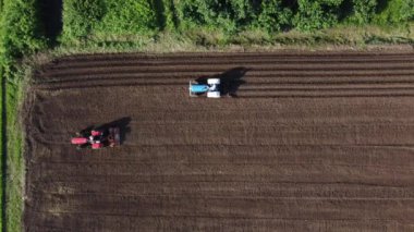 Tarımsal alan hava görüntüsü. Traktörler ekim için tarla sürüyor. Tarım alanında çalışan çiftçiler.