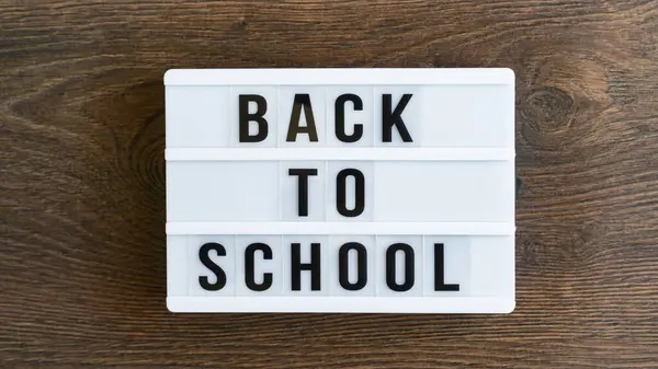 stock image Back to school concept. School supplies on wooden background. Back to school lettering on white letter board. Copy space for text. Selective focus included.