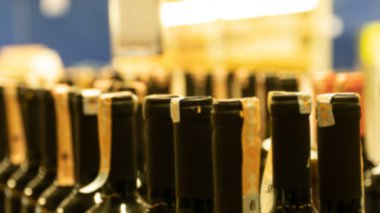 Alkol şişeleri manzarayı kapatır. Alkolden vergi artışı. Market rafında alkol şişeleri. Seçici odak dahil