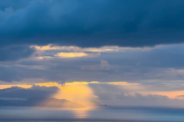 Gün batımı gökyüzü. Dramatik gökyüzü manzarası. Denizin üzerinde güneş ışığı.