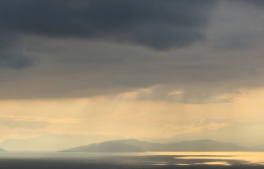 Gün batımı gökyüzü. Dramatik gökyüzü manzarası. Denizin üzerinde güneş ışığı.