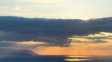 Gün batımı gökyüzü. Dramatik gökyüzü manzarası. Denizin üzerinde güneş ışığı.