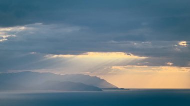 Gün batımı gökyüzü. Dramatik gökyüzü manzarası. Denizin üzerinde güneş ışığı.