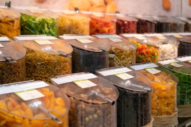 Dükkandaki plastik kaplarda çeşitli kurutulmuş meyveler.