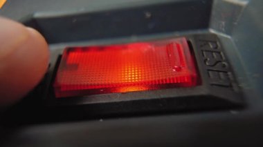 Siyah uzatma kablosunun kırmızı düğmesine parmağınızla basarak güç kaynağını kapatın. İyileş. Tasarruf kavramı. Fünyeli aşırı elektrik yükleme ve güvenlik filtresi fikri.