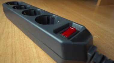 Parmağınızla kırmızı düğmeye basarak uzatma kablosunun prizine takın. Süzgeç. Tasarruf kavramı. Fünyeli aşırı elektrik yükleme ve güvenlik filtresi fikri.