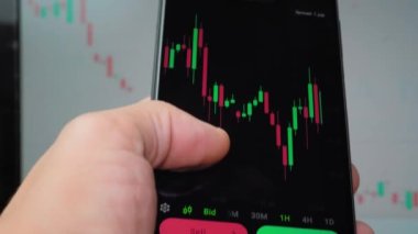 İşadamı tüccar yatırımcı analisti cep telefonu uygulamasını kullanarak kripto para birimi finans piyasasını analiz ediyor, akıllı telefondan ticaret verilerinin şemasını çıkarıyor. arkaplan çalışmasında grafik görüntülenir