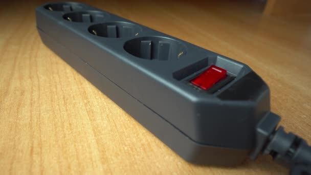 指で黒い延長コードの赤い押しボタンスイッチを押すことで電源をオフにします ヒールだ 貯蓄の概念 ヒューズ付き電気過負荷および安全フィルタのアイデア — ストック動画