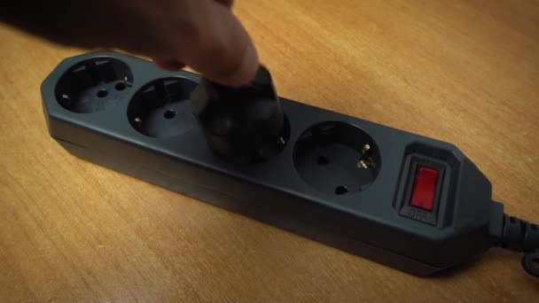 指で赤い押しボタンスイッチを押すことで 拡張コードソケットにプラグを挿入します フィルターだ 貯蓄の概念 ヒューズ付き電気過負荷および安全フィルタのアイデア — ストック動画