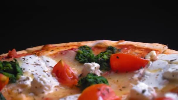 おいしいおいしいホット新鮮なイタリアのピザチーズ薄い地殻の上にトレイのクローズアップで回転します トマトと焼きたてのピザのトップビュー 黒い木製のテーブルとテキスト用のスペース — ストック動画