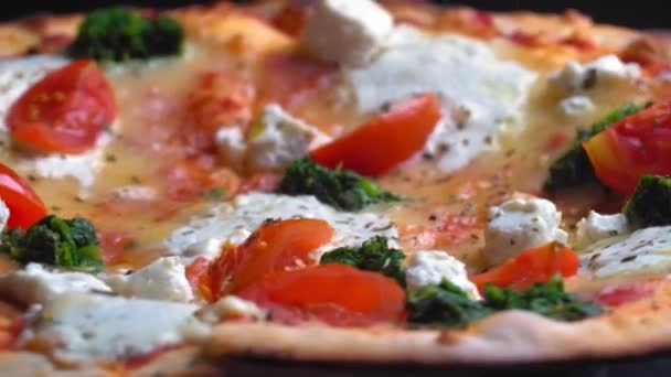 おいしいおいしいホット新鮮なイタリアのピザ鶏とチーズの薄い地殻の上にトレイのクローズアップで回転します トマトとチーズのモッツァレラチーズと焼きたてのピザのトップビュー ファーストフードピッツェリアのコンセプト — ストック動画