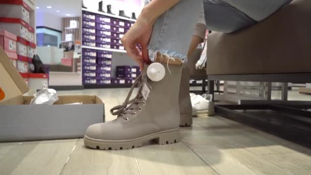 Uma Jovem Jeans Experimenta Sapatos Novos Enquanto Senta Cadeira Loja — Vídeo de Stock