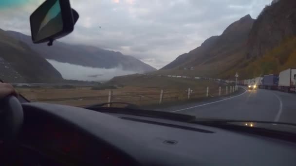 ビューの車から道路には 山や雲の窓の外 山の谷の風景 雨が降っている 水滴がガラスに蓄積している 車で旅行の概念 ブラシだ 山の風景 — ストック動画