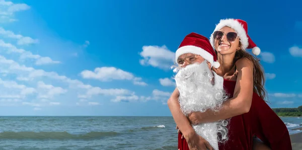 Papai Noel Segura Suas Costas Uma Jovem Mulher Sorridente Chapéu — Fotografia de Stock