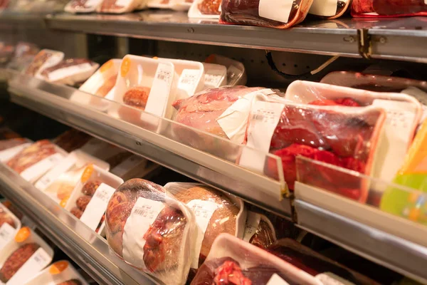 stock image Close-up of fresh, raw chicken offal packaged in individual packaging on the counter in the store, selective focus