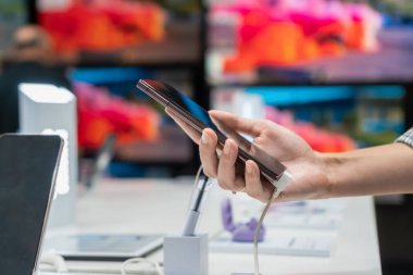 Yakından bakınca, bir kadın müşterinin cep telefonundan siyah akıllı telefon seçtiğini görüyoruz. Zor karar, farklı seçim.