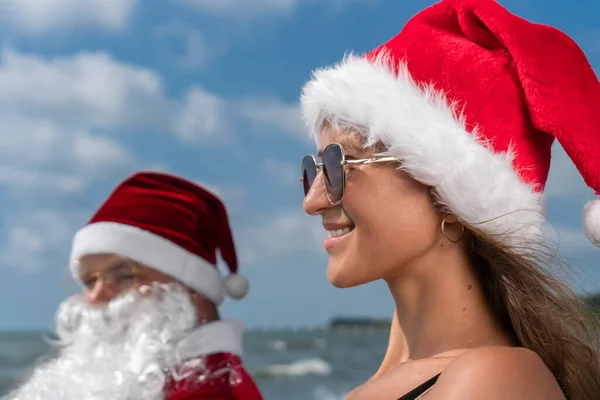 Noel Baba Şapkalı Güneş Gözlüklü Gülümseyen Genç Bir Kadının Portresi — Stok fotoğraf