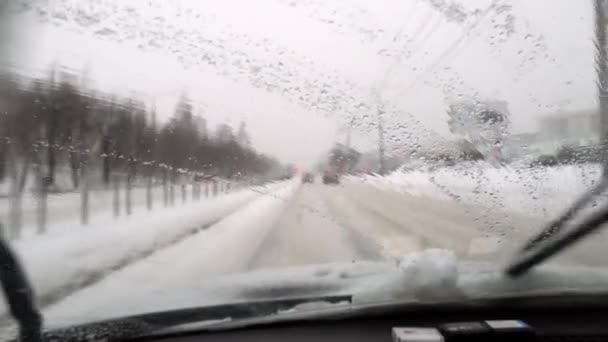 在暴风雪中开车 司机的玻璃在被冰雪覆盖的路上的能见度很低 在暴风雪中驾车穿过城市街道 前景光明 挡风玻璃 — 图库视频影像