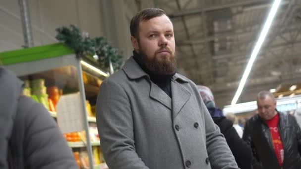 Young Man Gray Coat Beardos Stands Supermarket Background Large Number — Vídeo de Stock