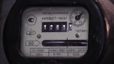 Mogilev, Belarus - January 2, 2023: : Old-fashioned meter for measuring electricity consumption with rotating disk and analog display for measuring kilowatt-hours in old residential apartment. Russian