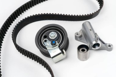 Timing belt and tension rollers of the gas distribution system of the automobile engine, the concept of car maintenance. New set of spare parts on a white background.