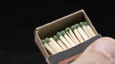 Box of matches in his hands. Box with close-up wooden matches in hands of man. He pushes out part and shows lot of matches.