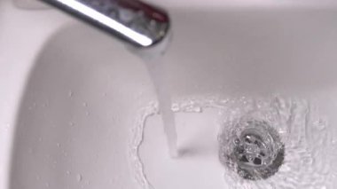 Close-up stainless steel sink hole filled with water. Water pours from water tap, but water drain does not cope and congestion is formed. Wastewater, assistance in case of plumbing breakdown.