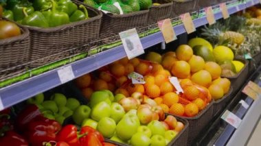 Large number of citrus fruits lie in containers on counter in large supermarket. Fresh fruits as product with vitamins on supermarket shelf. Imported fruits, sanctions.
