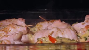 Tasty chicken meat portions in pan. Frying or roasting processing. Preparing food on kitchen stove. Drumstick and chicken legs are fried in slow motion.