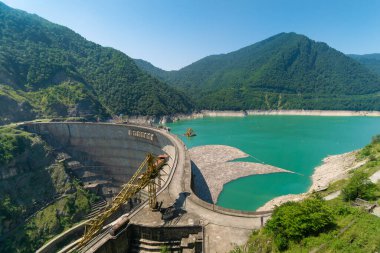 Güneşli bir günde Ingur hidroelektrik santralinin manzarası. Gürcistan 'ın dağlarla çevrili Inguri Barajı yakınlarındaki Inguri Jvari Nehri rezervuarı. Dünyanın en uzun beton barajlarından biri.