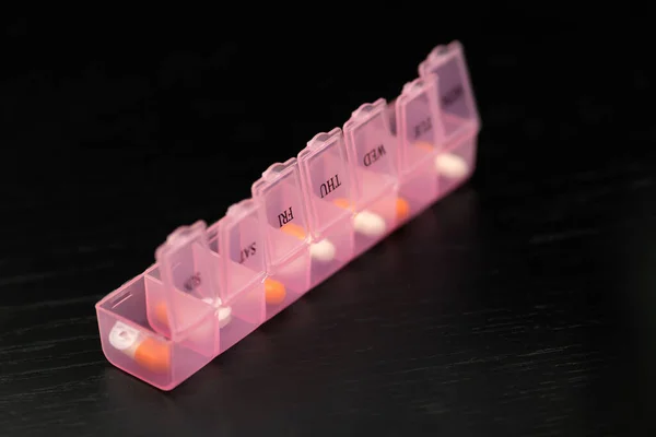 Primer Plano Pillbox Rosa Con Cápsulas Tabletas Sobre Una Mesa — Foto de Stock