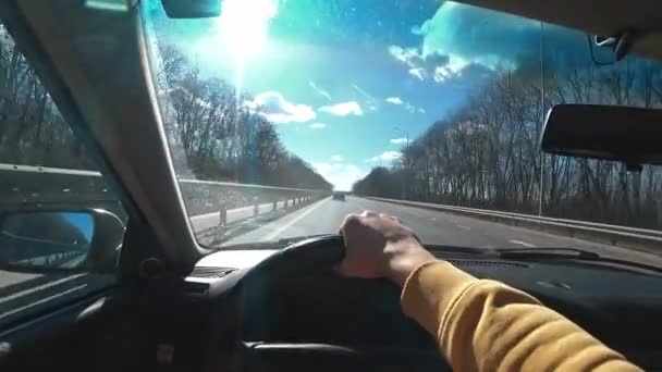 汽车在公路或高速路上行驶的动作摄像 驾驶汽车的人手握方向盘 上路旅行 在阳光明媚的冬季开车 — 图库视频影像