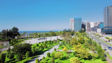 Georgia 'daki Batumi tatil köyü. Güneşli bir günde denizin arka planında yeşil parkın havadan görünüşü. Lehi ve Maria Kaczynski Parkı. Güzel yeşil peyzaj. Altyapı, dağlar