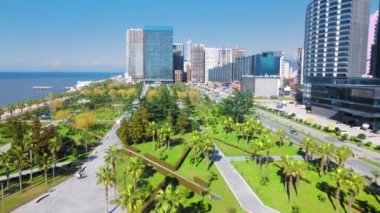 Georgia 'daki Batumi tatil köyü. Güneşli bir günde denizin arka planında yeşil parkın havadan görünüşü. Lehi ve Maria Kaczynski Parkı. Güzel yeşil peyzaj. Altyapı, dağlar