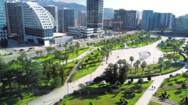 Georgia 'daki Batumi tatil köyü. Güneşli bir günde denizin arka planında yeşil parkın havadan görünüşü. Lehi ve Maria Kaczynski Parkı. Güzel yeşil peyzaj. Altyapı, dağlar