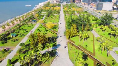 Georgia 'daki Batumi tatil köyü. Güneşli bir günde denizin arka planında yeşil parkın havadan görünüşü. Lehi ve Maria Kaczynski Parkı. Güzel yeşil peyzaj. Altyapı, dağlar