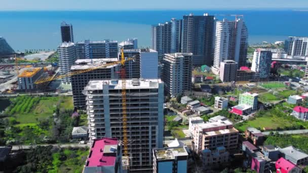 在海山的背景下 俯瞰高楼大厦的建筑 格鲁吉亚巴统海岸繁忙的建筑工地和建筑设备 — 图库视频影像