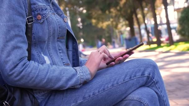 Mujer Jeans Chaqueta Mezclilla Sentada Parque Absorbió Teléfono Inteligente Sus — Vídeo de stock