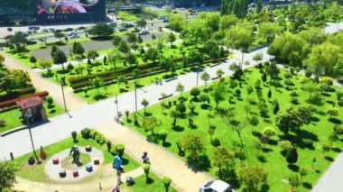 Gürcistan, Adjara 'da güneşli bir günde, yeni bulvardaki güzel parkın insansız hava aracı manzarası. Deniz ve palmiye ağaçlarının kuş bakışı görüntüsü. Modern binalar ve dağlar.