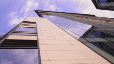 Modern konut binaları arasındaki dar geçit. Yüksek binalardan oluşan duvarlar ve aralarında dar bir gökyüzü şeridi. Modern kentsel yerleşim alanları. Alt manzara. kamera döndürmesi.